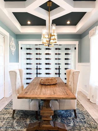 Dining room with wooden table, chairs, and a wine rack on the wall.