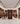 Wine store interior with wooden shelves and wine bottles, people interacting.